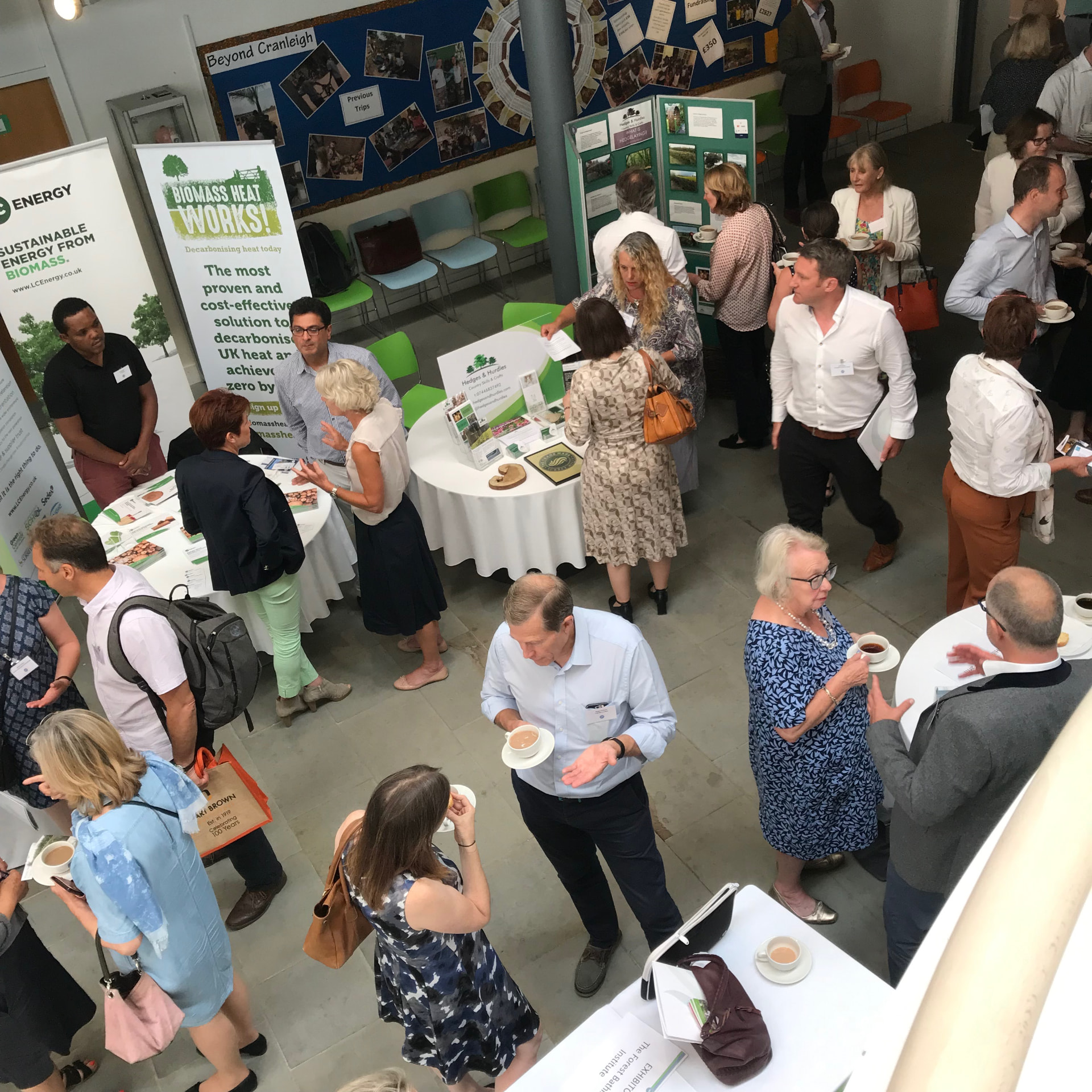 Members and exhibitors networking around stands at a Surrey Hills conference